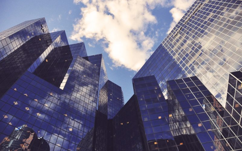 Low-angle shot of several skyscraper towers with reflective glass facades