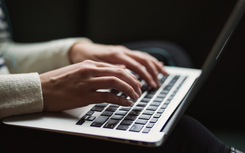 Fingers hovering over laptop keyboard